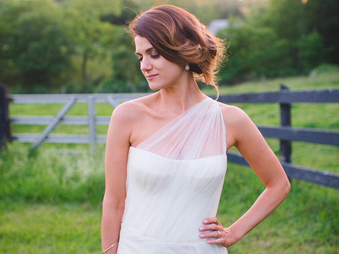 peinado recogido en escote asimétrico en vestido de novia en el campo