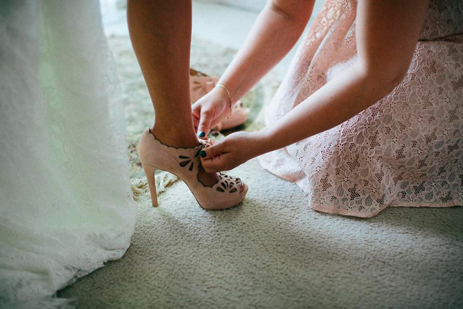 dama de honor anudando los zapatos de la novia