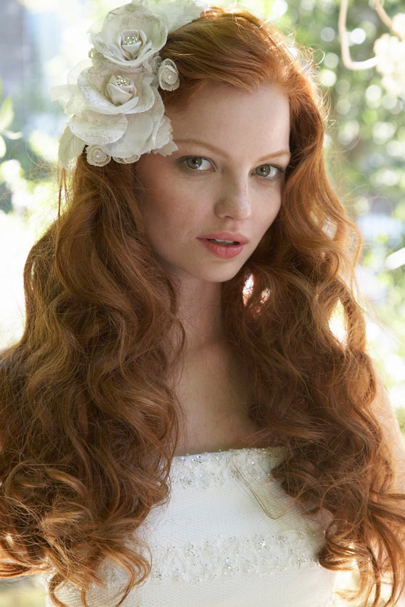 novia con pelo suelto rizado y broche en forma de flor